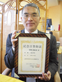 記念日登録証を手にする中澤雅孝代表取締役