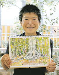 作品を手に待つ中西さん