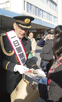 通行人にチラシを手渡す福本さん