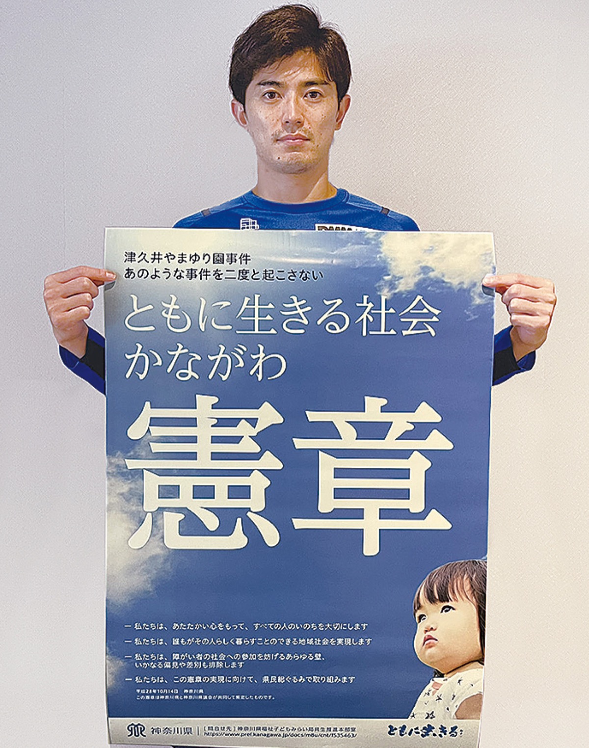 憲章ポスターを持つ谷口彰悟選手