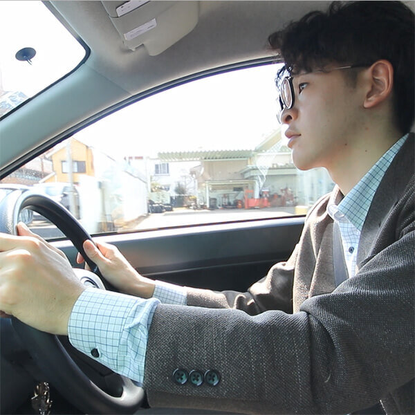 タウン号（社用車）を運転する男性