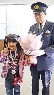 花束を渡し笑顔を見せる前田菜月さんと副署長