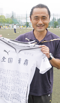 桐蔭高が日本一に輝いた３年前の夏、山本富士雄前監督が着ていたシャツを手にする賤機さん
