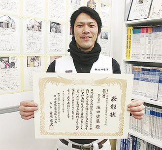 「全日本ベスト塗装店賞」の賞状を手にする、青葉店の上尾政裕さん