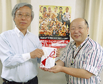 チケットを手渡す平田会長（左）