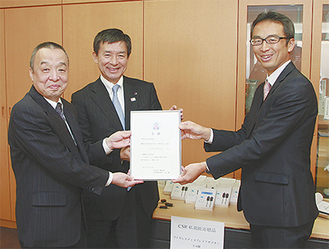 目録贈呈式。左から亀山校長、工藤代表、石坂支店長