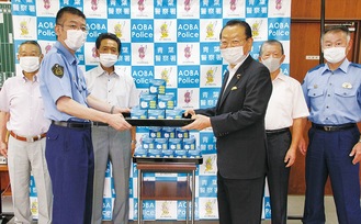 マスクを櫻庭署長（左）に手渡す松澤会長