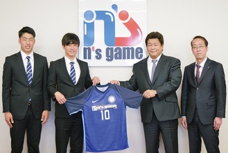 ロゴ入りのユニフォームを手に（右から）光本達夫代表取締役、長谷川会長、鍋田主将、早坂勇希選手