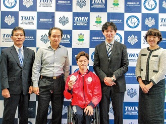 銀メダルを手に結果を報告する古澤選手（中央）
