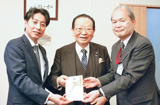 岩坪事務長（右）に目録を手渡す横田支店長（左）と松澤氏