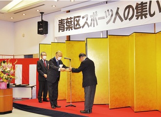 受賞者を表彰する小澤明夫区長（中央）と菊池会長（左）