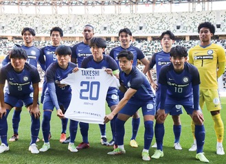 増尾さんのユニフォームを掲げ、共に優勝を喜ぶ選手たち