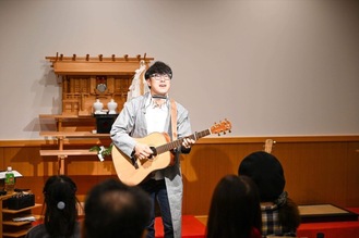 神社の施設内で歌う佐々木さん＝提供