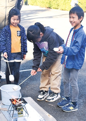 焚火でマシュマロを焼く子どもたち