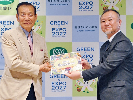 贈呈式で本を受け取る平岡校長（右）