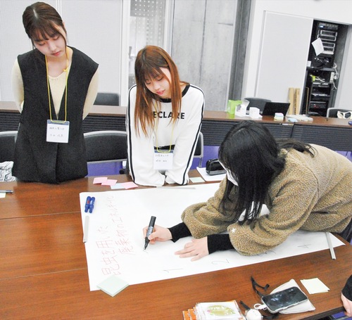 アイデアを模造紙に書き出す学生ら