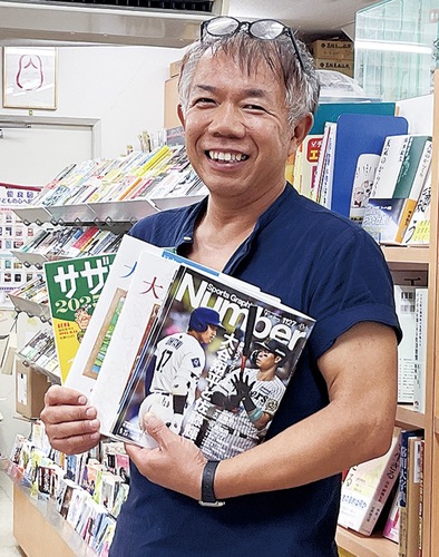 書籍を手に、笑顔の大河原さん