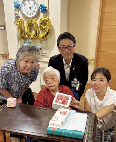 前列中央が鈴木さん、左から三村副会長、中島区長＝区提供