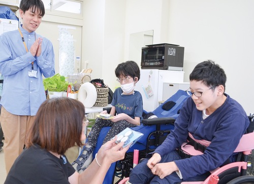 地域住民へテープを贈る森さん（右）