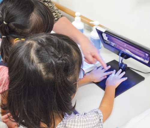 洗い残しをチェックする子どもたち