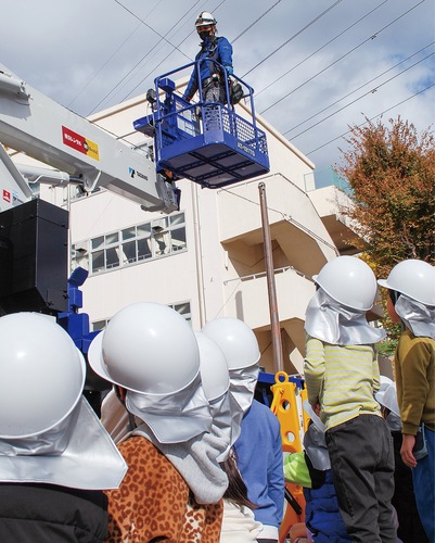 高所作業車を見上げる児童ら