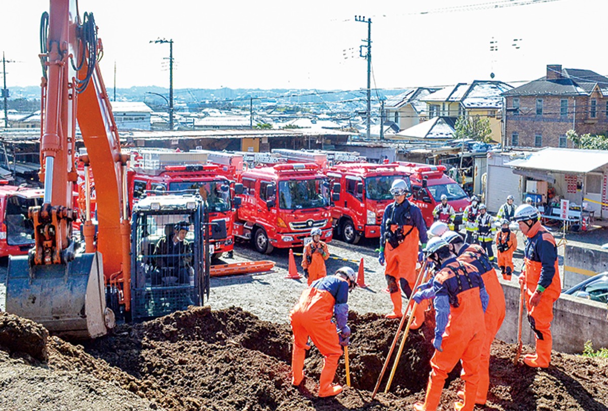 検索棒でダミー人形の位置を探る隊員ら