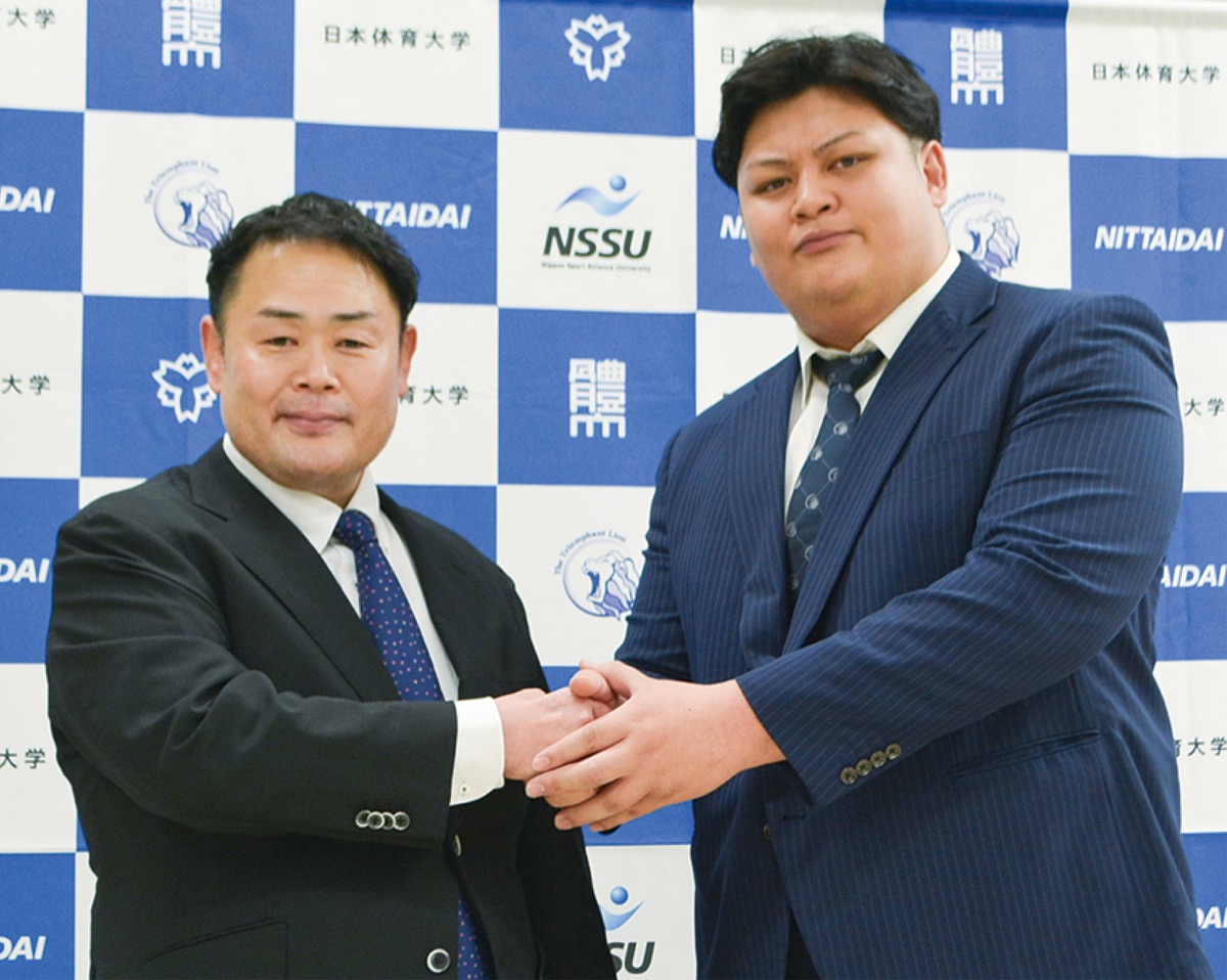 固く握手を交わす雷親方（左）とクリストファーさん