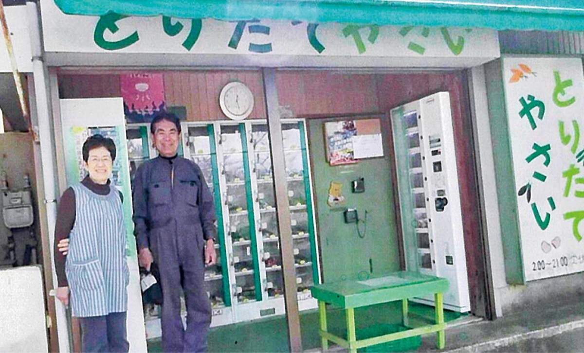 以前の直売所に立つ八重子さん（左）と惠一さん＝本人提供