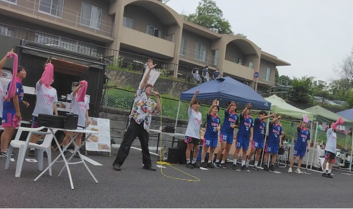 『繋がる世界』を熱唱するHACHIさんと選手たち
