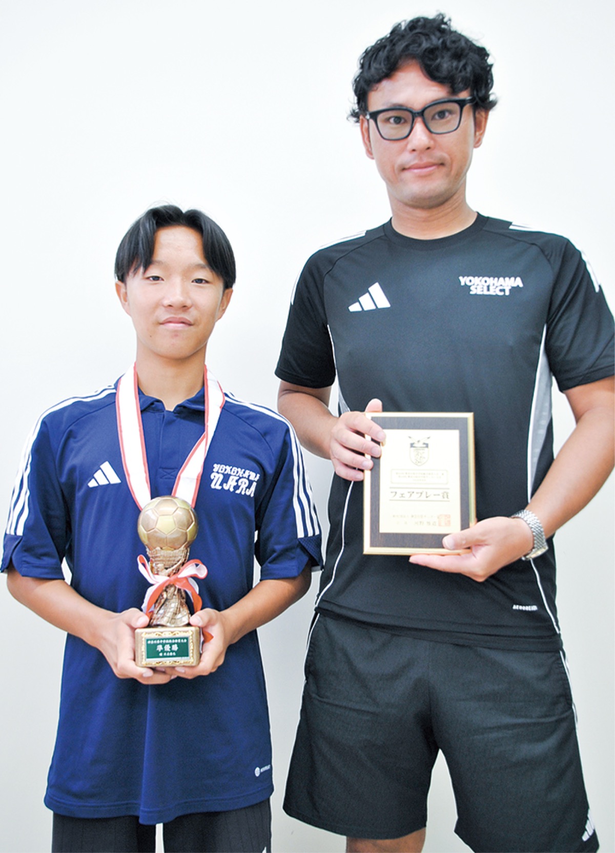 県大会のトロフィーと表彰状を持つ、三戸主将と木村監督(右)