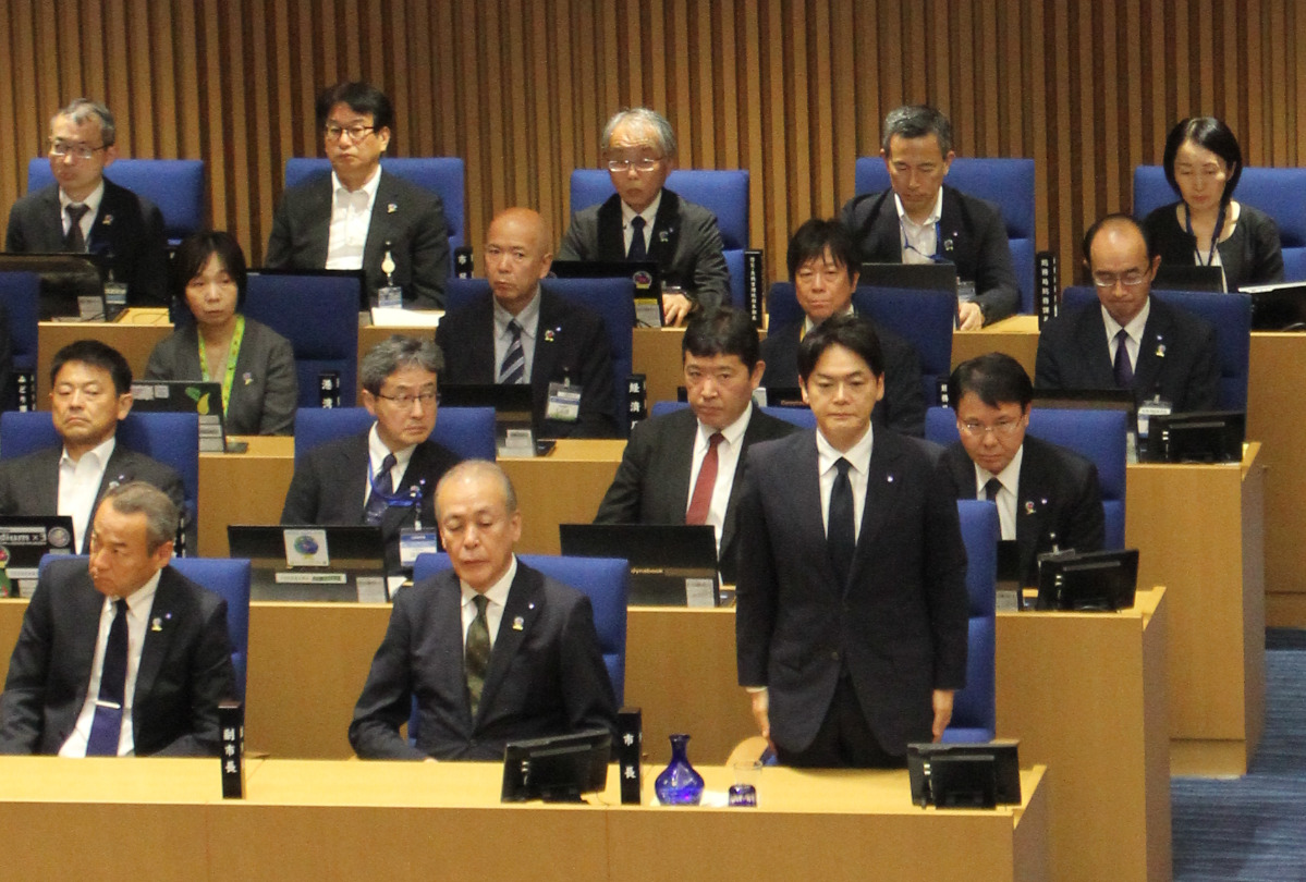 辞職が同意され、立ち上がる山中氏