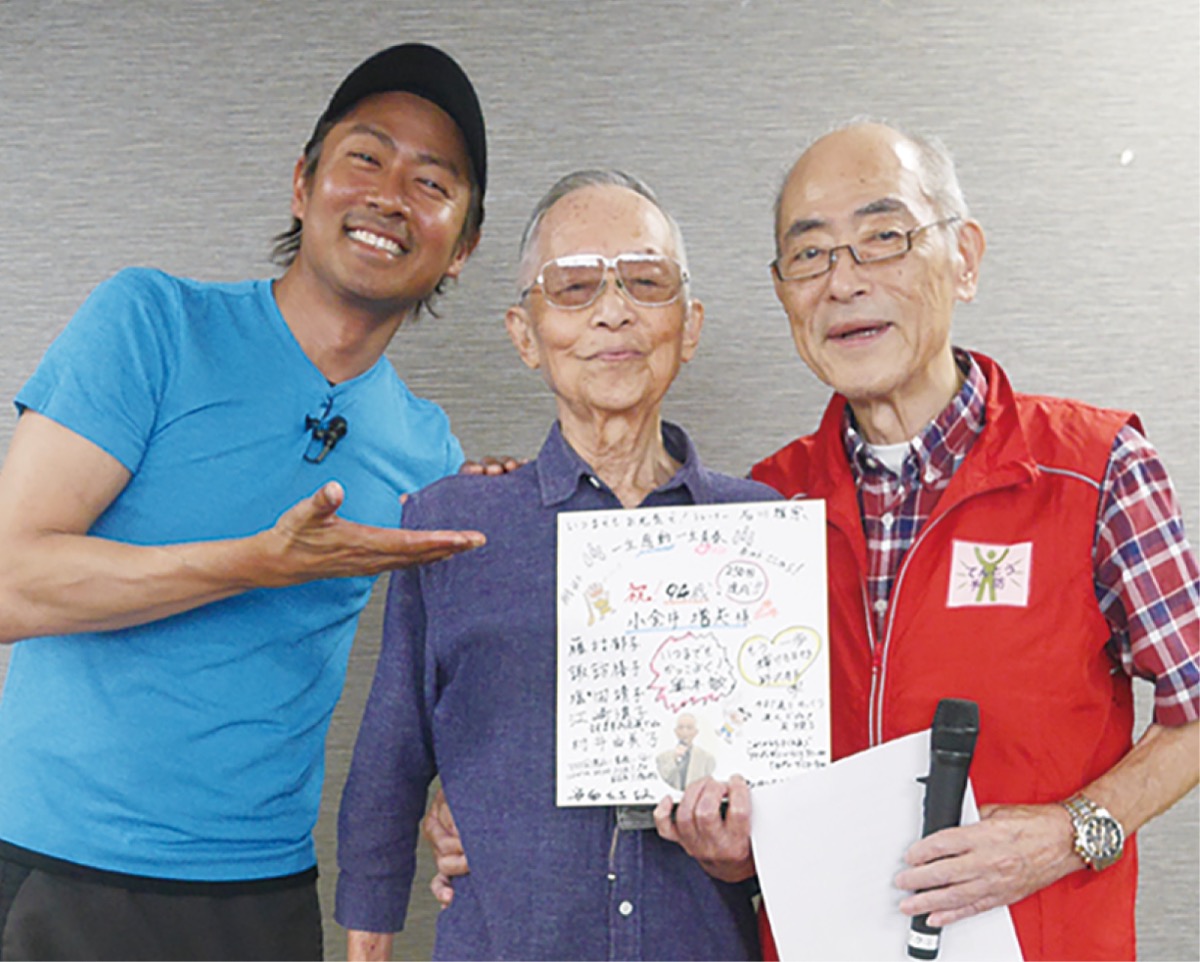 同教室トレーナーの石川雅宗さん（左）と朝香さん（右）に祝福される小金井さん