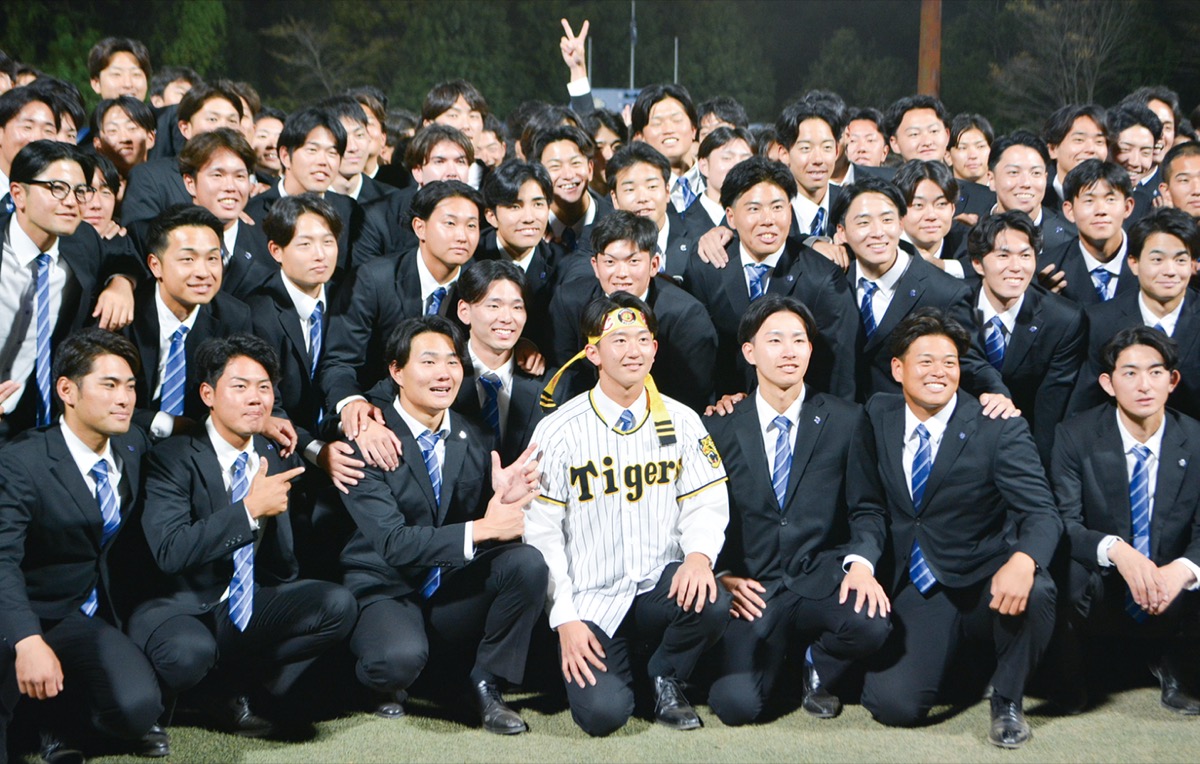 阪神タイガースのユニフォームを身にまとい、部員らと記念撮影をする馬場投手(前列中央)