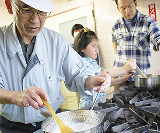 チーズ作りを指導する松井さん（左）