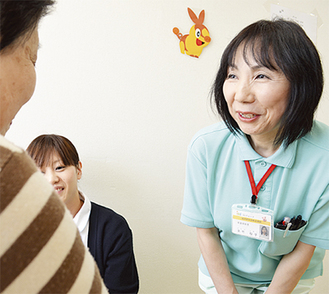看護師と共に患者と談笑する矢竹さん（右）