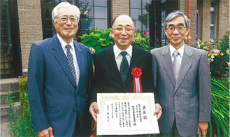 賞状を手に笑顔の大川会長（中央）と愛護会メンバー