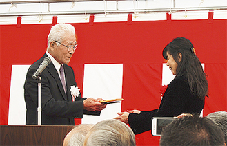吉濱さんに記念楯を贈る持田会長（左）