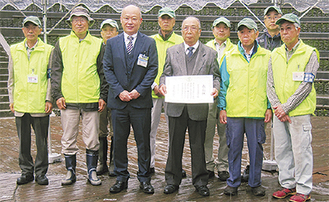 表彰状を手にする大川会長（中央右）と小野崎区長、会のメンバーら