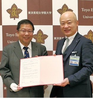 協定書を持つ池田学長（左）と小野崎緑区長