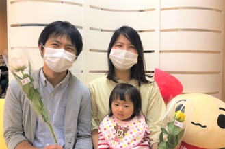 バラの花を手に笑顔を見せる松田さん夫婦（同血液センター提供）