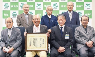表彰状を掲げる保谷代表（前列左から２人目）と岡田区長（同右から２人目）ほか、同研究会メンバー