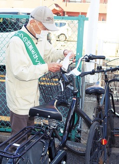 放置自転車に警告札を付ける参加者