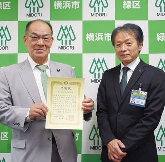 感謝状を手にする塚田会長（左）と岡田区長