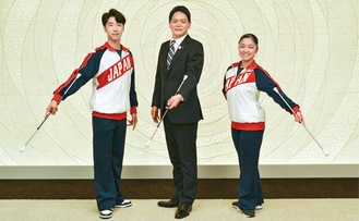 バトンを持つ３人。左から齋藤さん、山中市長、平田さん
