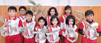 自らの手で作り上げたしめ縄を手にするレインボーインターナショナルスクールの児童たち（提供写真）