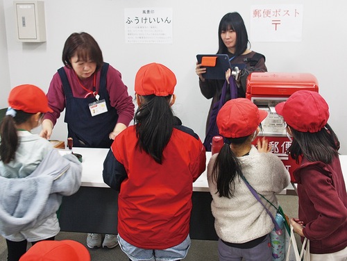 風景印を押した後、はがきを投函する体験をした子どもたち