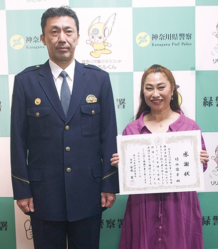 緑警察署の署長室で金成署長（左）から感謝状を受け取った竹山さん