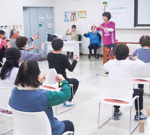 脳トレの一環である指の体操を体験する参加者