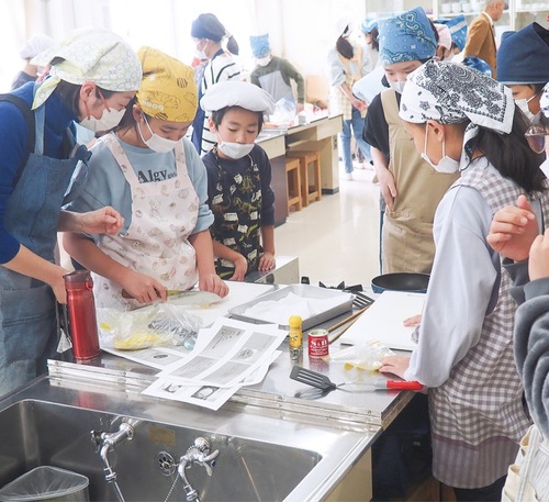 レシピを見ながら真剣に料理に取り組む児童たち