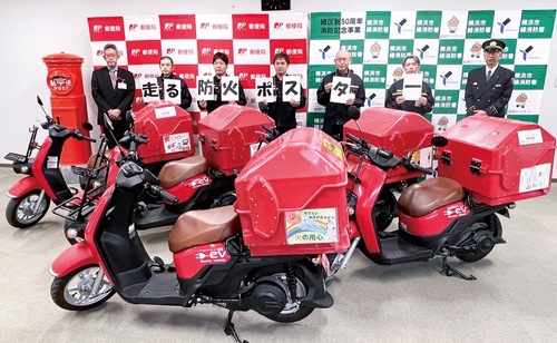 児童の作品を掲示した集配用バイク。後方左から石田局長、集配営業部社員、寺山署長（提供写真）